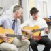 Gitar çalışması yapan çocuk ve yetişkin