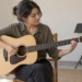 Çelik telli akustik gitarla çalışma yapan yetişkin.
