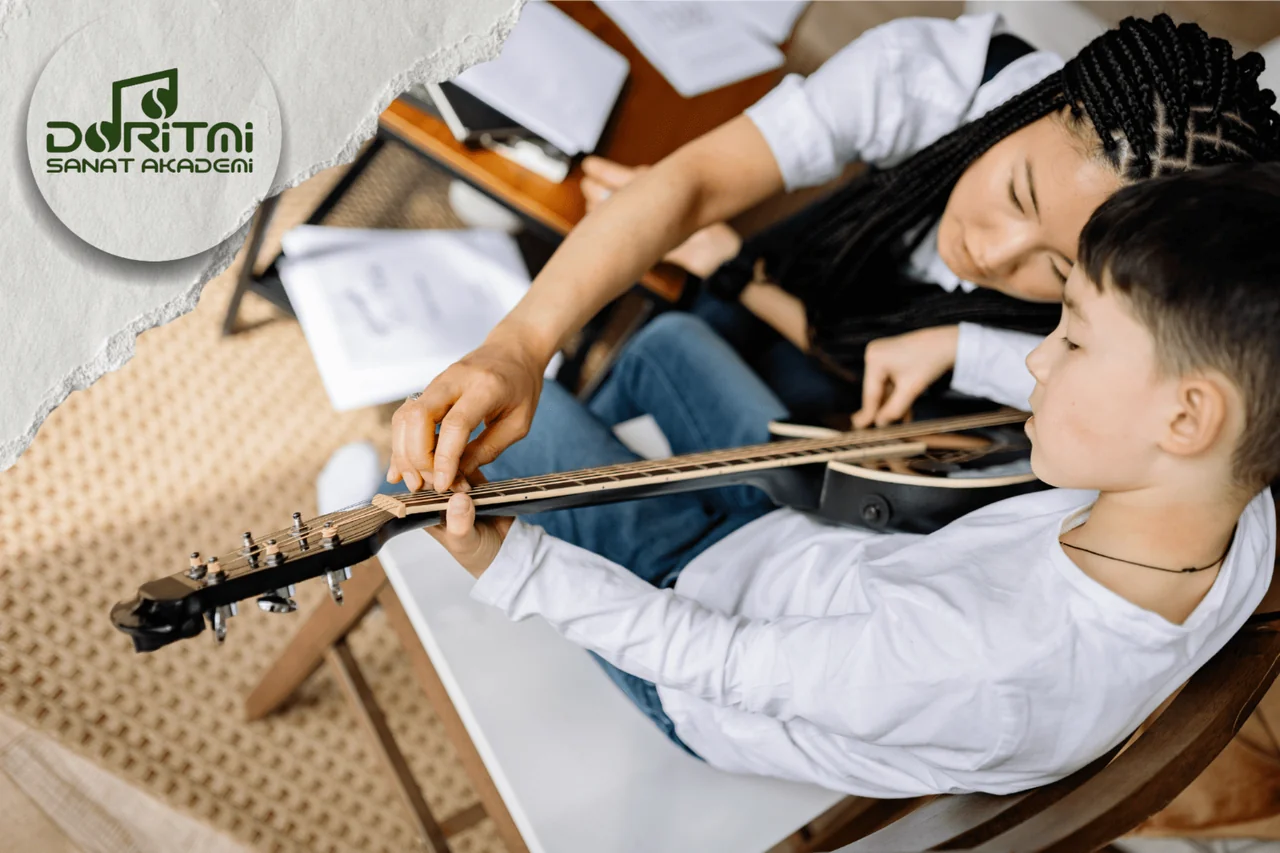 Nota sayfaları önünde gitar çalışan çocuk ve yanındaki yetişkin.