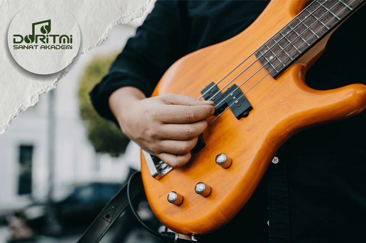 Açık alanda bas gitar çalan kişinin elleri.
