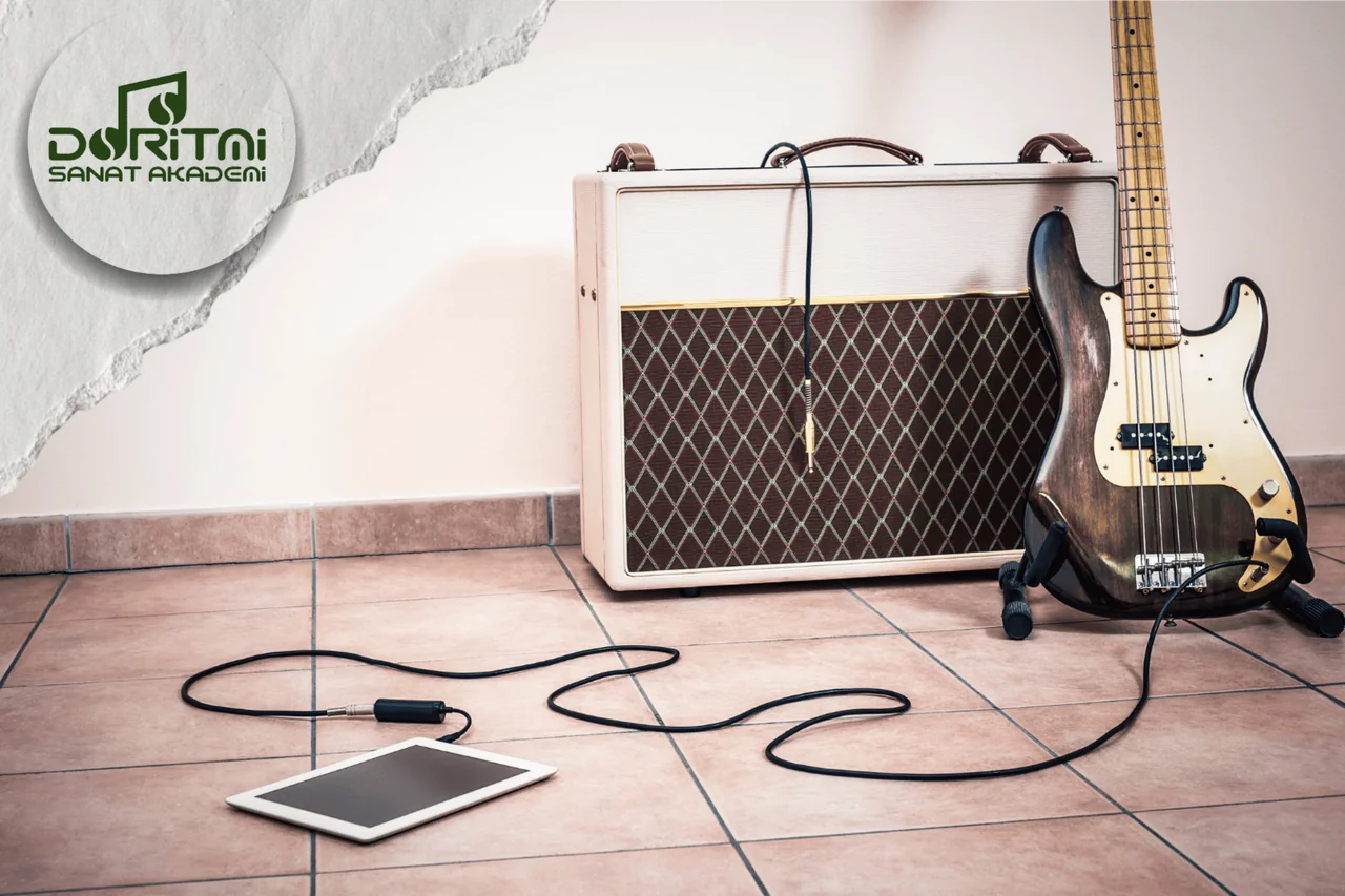 Amplifikatör yanında duran bas gitar ve bağlantı kabloları.