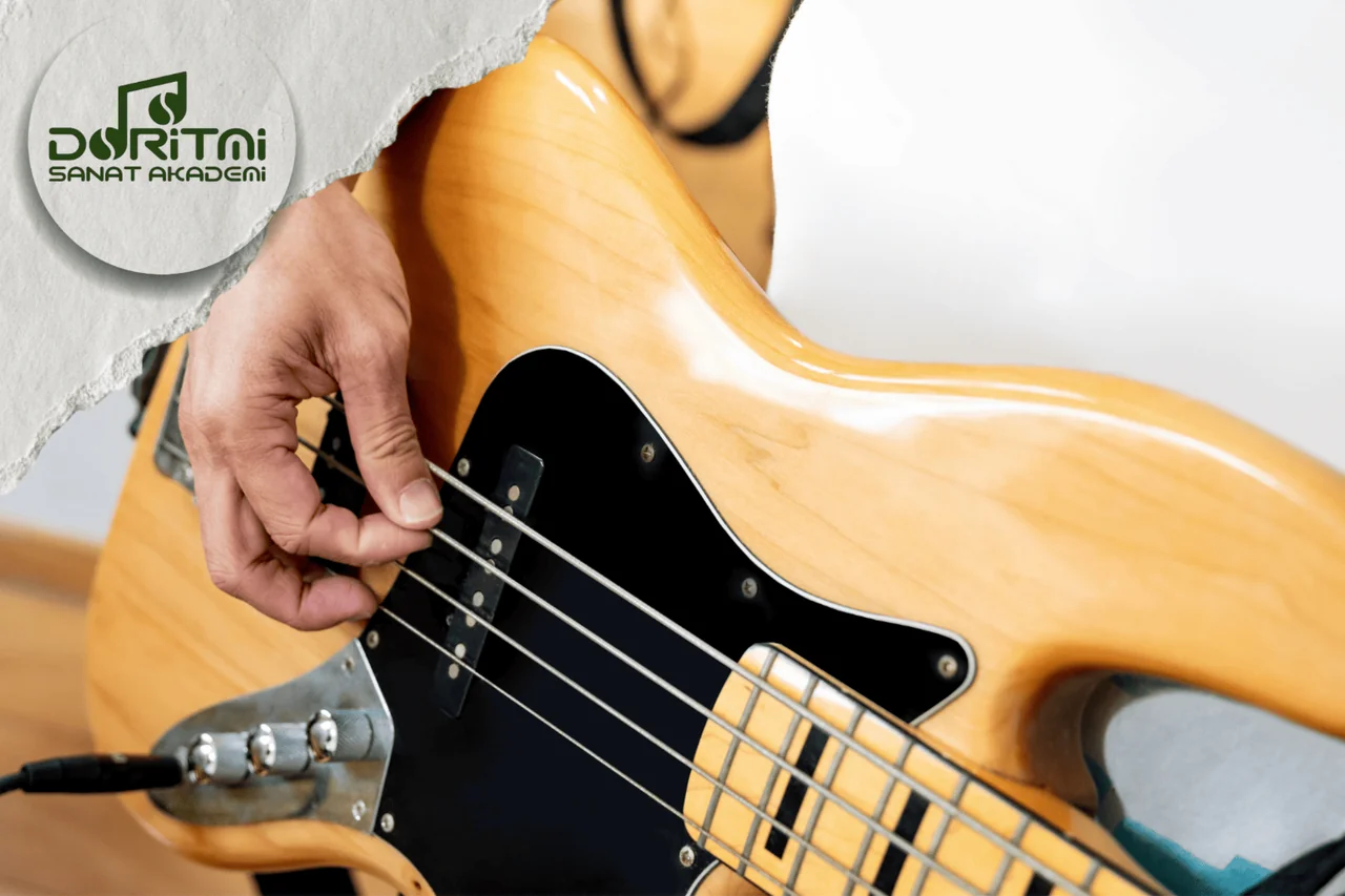 Sarı bas gitarın tellerini çalan el yakın plan.