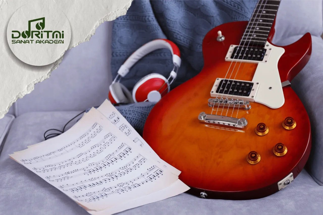Elektro gitar, kulaklık ve nota sayfaları.