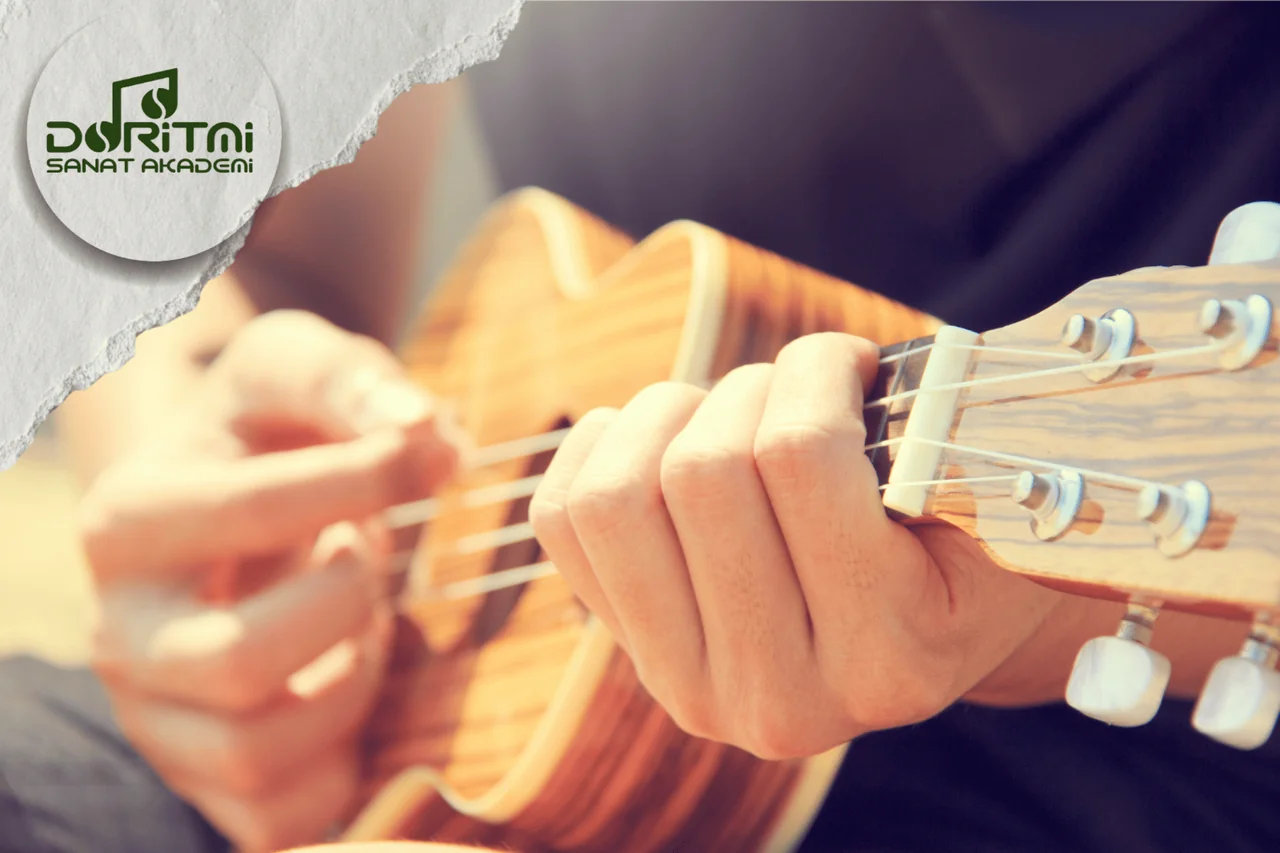 Ukulele tellerini çalan ve perdelere basan eller yakın plan.