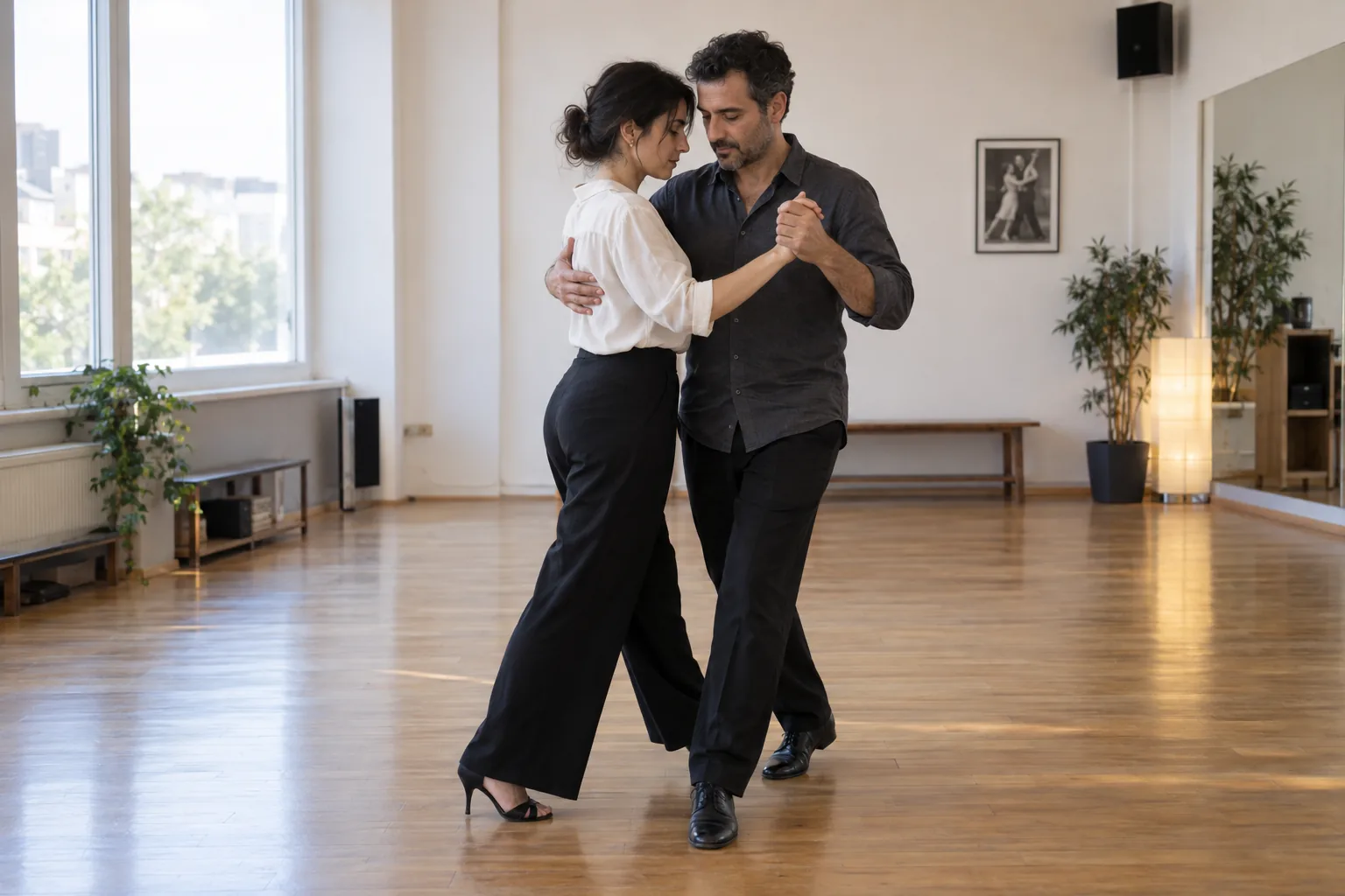 Stüdyoda tango yürüyüşü ve partner tutuşu çalışan iki yetişkin.
